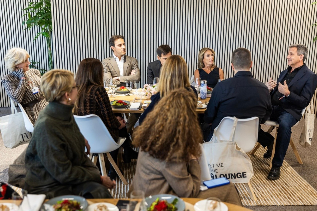 Diverse business professionals in circular discussion at EY Davos meeting, seated around table in modern setting