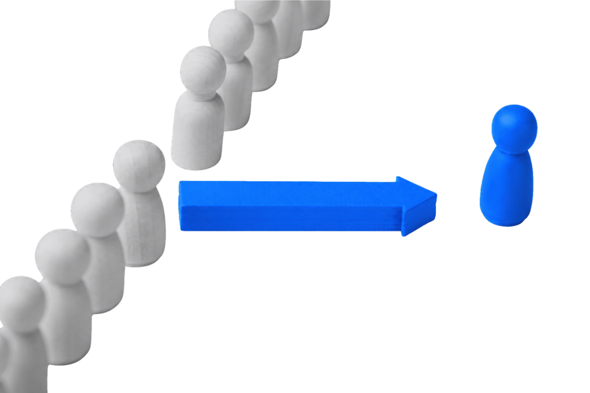 A row of white figurines stands in formation against a black background, while a bright blue arrow points toward a single bright blue figurine positioned separately on the right, symbolising direction, change, leadership, or focus.