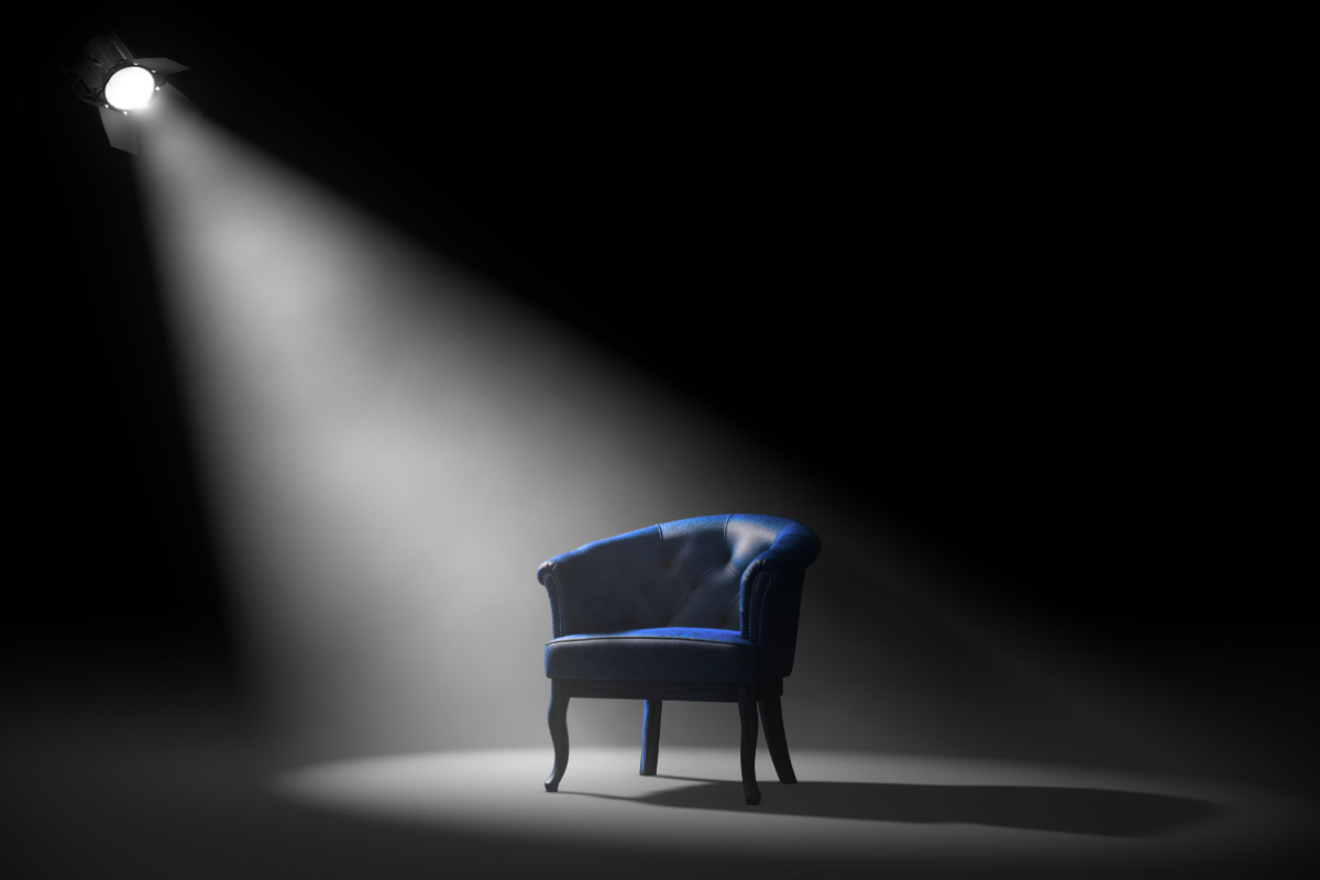 A blue arm chair under the spotlight