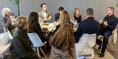 Diverse business professionals in circular discussion at EY Davos meeting, seated around table in modern setting