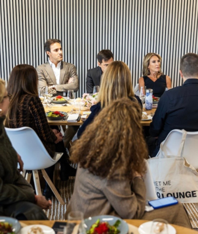 Diverse business professionals in circular discussion at EY Davos meeting, seated around table in modern setting