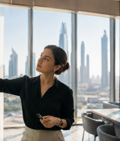 Marketing leader developing ideas on a glass wall in a modern Dubai office, reflecting ambition, experimentation and visible impact.